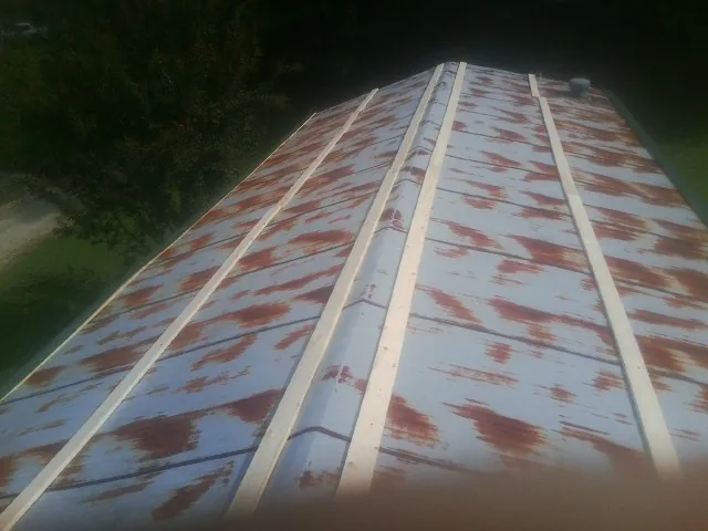 Rusted metal roof panels with new wood purlins before replacement — Storm Damage Roof Repair in Hickory Grove by Roofing Brothers
