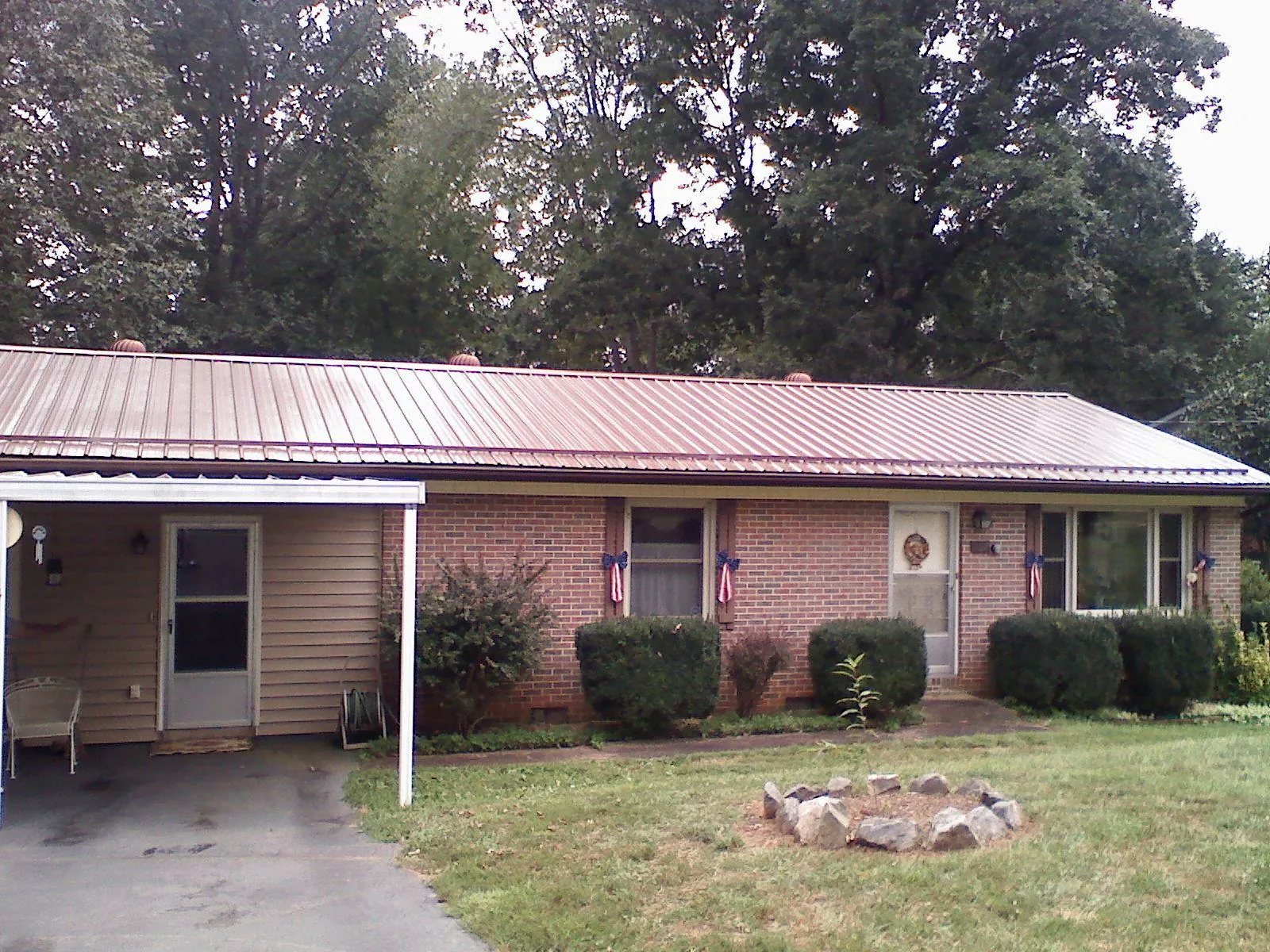 Bronze metal roof and carport on a brick ranch home — Roof Repair work by our crew in Hickory Grove