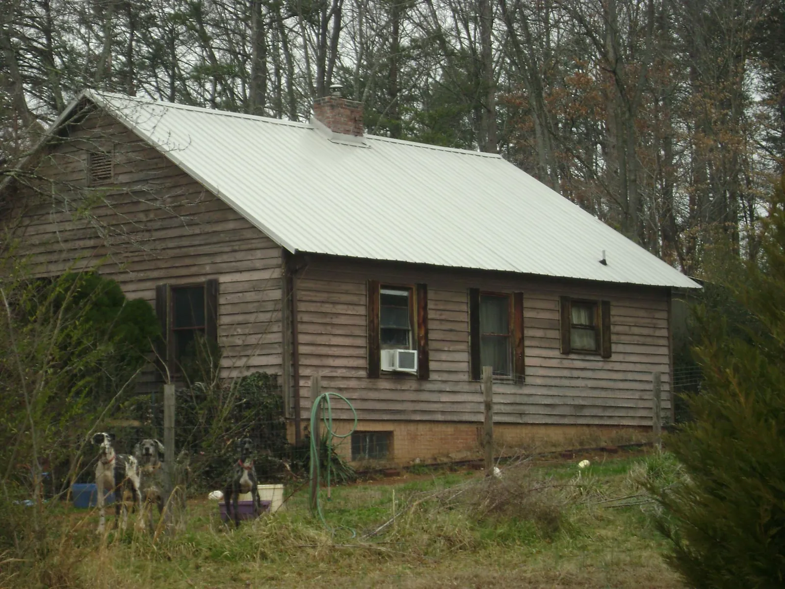 White metal roof on an old wood sided farmhouse, from a Metal Roof Installation job in Hickory Grove